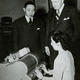A woman types on Kao's Chinese electric typewriter, as IBM president Thomas J. Watson looks on.